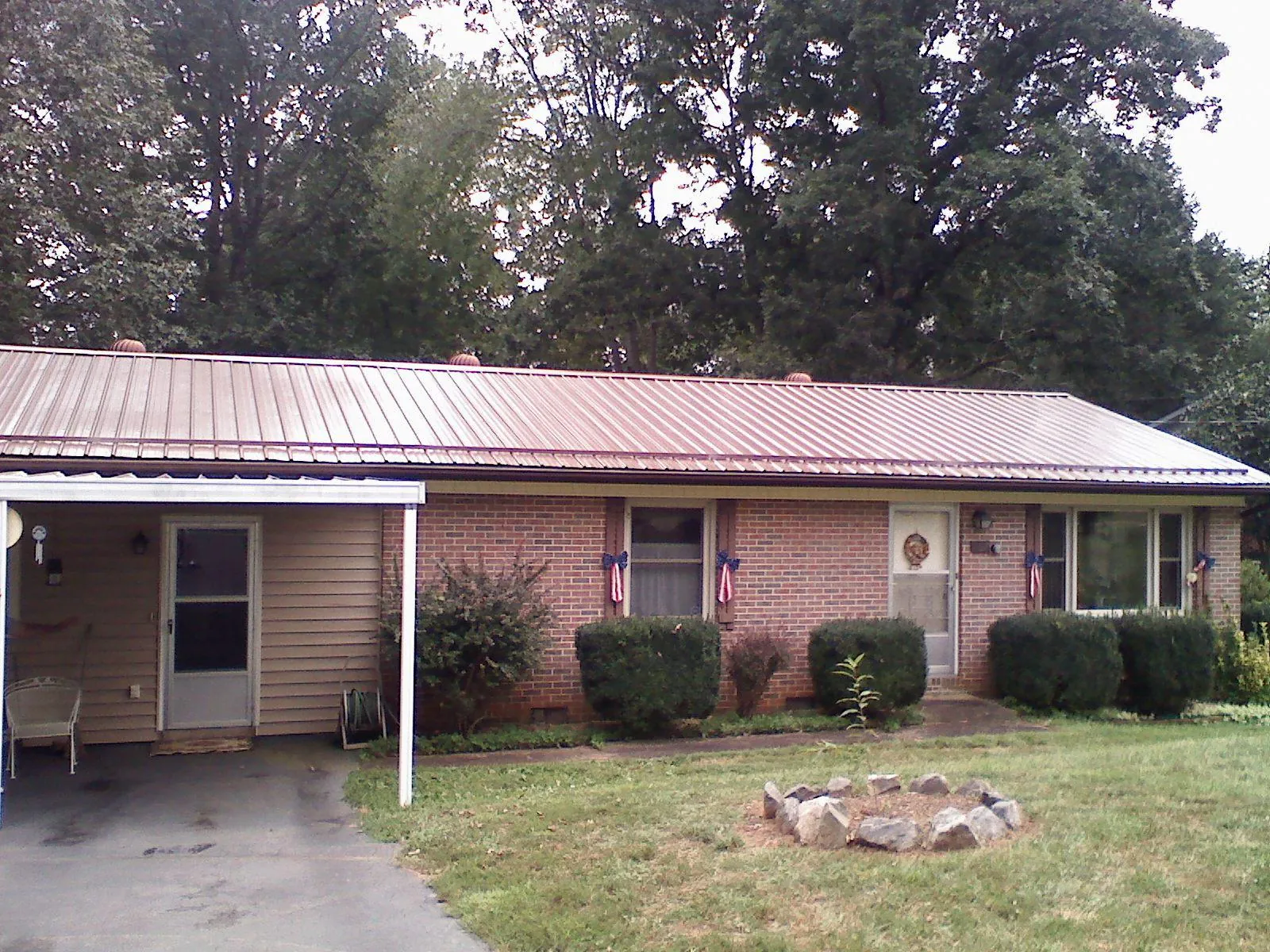 Bronze metal roof and carport on a brick ranch home — Roof Repair work by our crew in Sanford