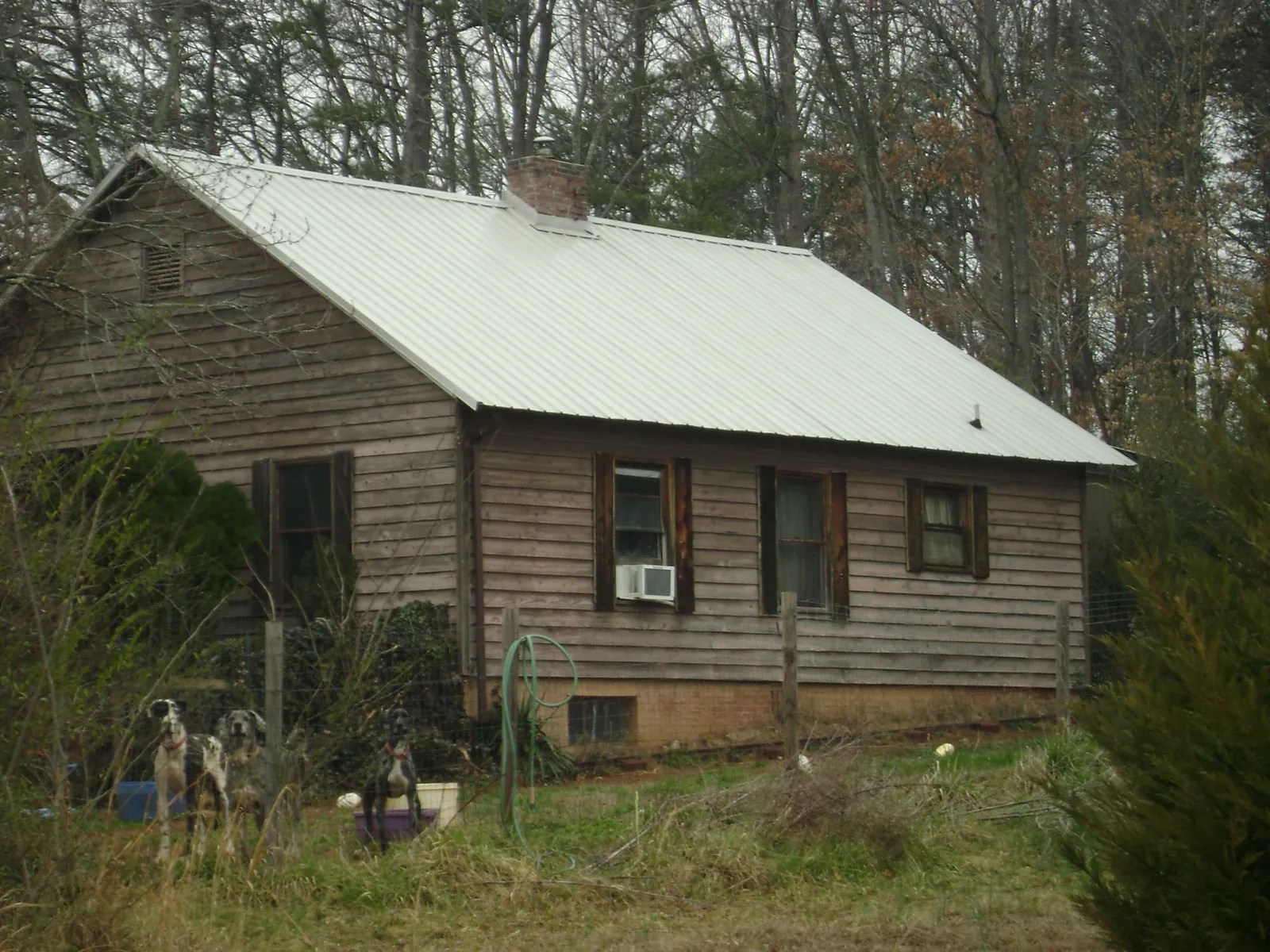 White metal roof on an old wood sided farmhouse, from a Metal Roof Installation job in Sanford